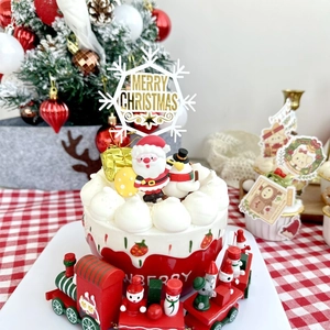 Detailed Christmas cake decoration with golden Merry Christmas topper and resin figurines