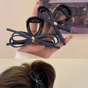 Détail de pinces à cheveux à nœud en denim avec boucle métallique en deux tailles