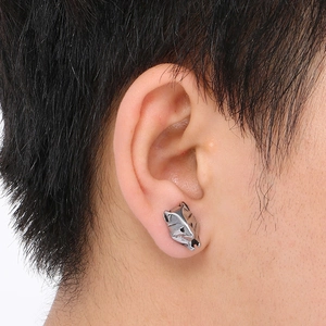 Close-up of a silver punk wolf head earring worn on ear showing 3D metallic texture