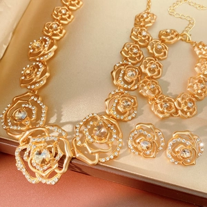 Detailed macro view of golden rose jewelry set with sparkling rhinestones and crystal flower petals