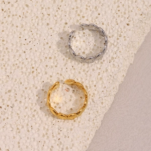 Detailed view of adjustable gold and silver heart rings on a white stone background
