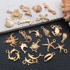Detail of assorted golden sea life charms including starfish, seahorse, and shell for DIY jewelry