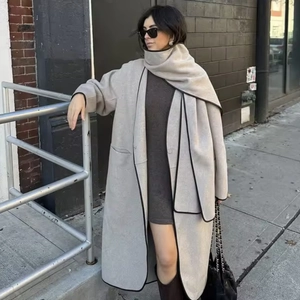 Minimalist wool coat with matching scarf set featuring black contrast piping trim on beige