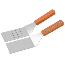 Detail of stainless steel spatula set with wooden handles and rivet construction