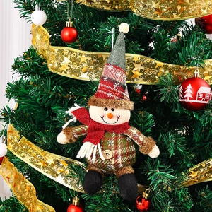 Detalle de un adorable adorno de muñeco de nieve a cuadros con bufanda en un árbol