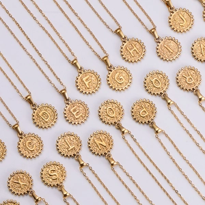 Close-up of 18k gold plated hammered round pendants with embossed alphabet letters
