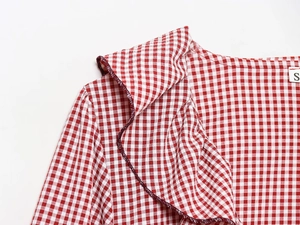 Detail of red and white checkered shirt showing pleated collar and fine stitching texture