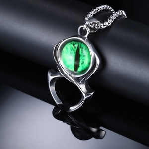 Vue macro d'un pendentif œil de démon gothique avec pupille de dragon verte et griffe