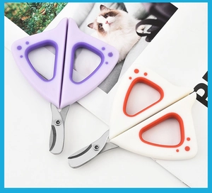 Detail of cat claw shape ergonomic handles on purple and orange pet nail clippers
