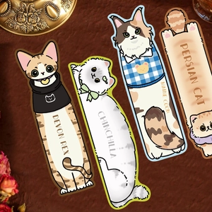 Set of four paper bookmarks with cartoon cat illustrations on a rustic textured surface