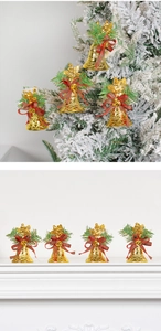 Set of 4 golden Christmas bells with pine needles and red bows on a festive tree branch