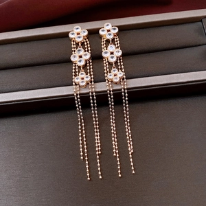 Detail of rose gold clover tassel earrings with zircon inlay and beaded chain fringe