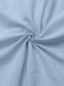 Close-up of light blue linen-cotton fabric texture with natural crinkle and drape