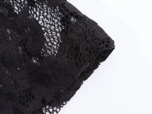 Close-up of intricate black floral lace pattern with delicate scalloped edges and mesh texture