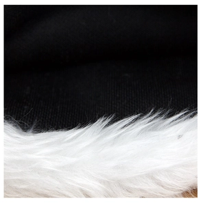 Detailed view of plush white faux fur trim against black holiday party hat fabric