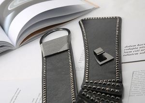 Detail of black leather punk belt with metal rivets and gunmetal buckle on fashion magazine