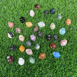 Assorted natural gemstone duck carvings in rose quartz and amethyst on green grass