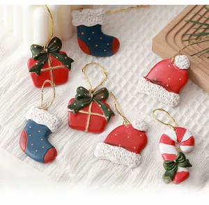 Mini resin Christmas ornaments set with festive socks and candy canes on white texture