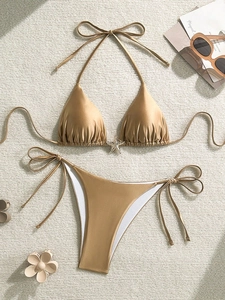 Primer plano del bikini dorado metalizado con detalle de estrella de mar y lazos