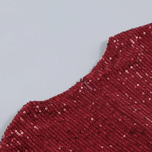 Gros plan sur le décolleté et la fermeture éclair invisible d'une robe rouge à paillettes