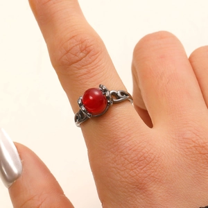 Detail eines Vintage-Rings mit Hohlmuster und einem großen roten Edelstein-Perle