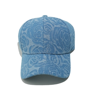 Close-up of blue denim baseball cap with floral rose jacquard and classic curved brim