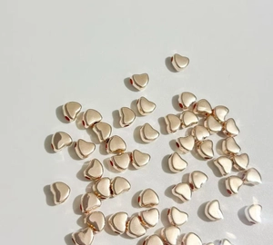 Gros plan de perles d'espacement CCB en forme de cœur or rose pour bijoux DIY et colliers