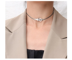 Macro view of silver buckle pendant on sleek snake chain choker necklace for women