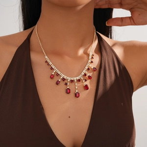 Luxurious two-piece gold tassel necklace with red gemstones and crystals on a model