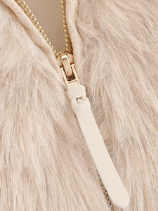 Macro shot of golden metal zipper on beige faux fur jacket with matching puller detail