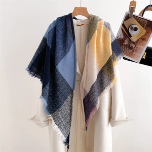 Detailed texture of colorful plaid cashmere-like scarf with soft fringe on a coat