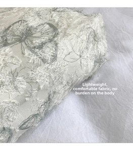 Detailed view of lightweight fabric with lace fringe texture and grey butterfly patterns