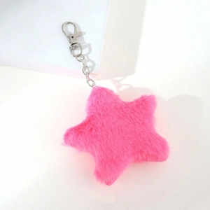 Macro shot of rose pink plush star keychain with silver metal clip on white background