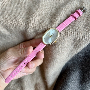 Elegant women's quartz watch with oval gold case and pink faux-crocodile leather strap