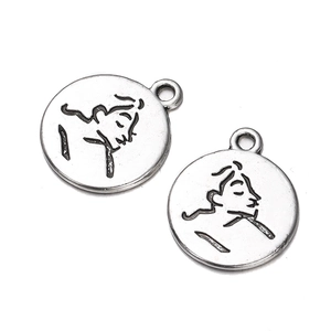 Macro detail of vintage silver-plated alloy coin pendant with abstract face profile carving