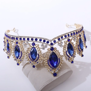 Detail of baroque gold bridal crown with large blue oval rhinestones and filigree design