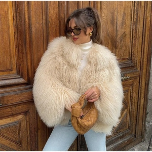 Veste courte en fausse fourrure beige à texture bouclée portée par un mannequin