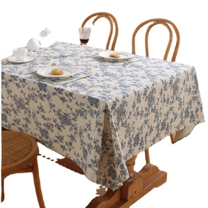 Blue and white floral cotton linen tablecloth displayed on a rustic wooden dining table
