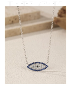 Detail of S925 silver paperclip necklace with sparkling blue devil eye pendant macro shot