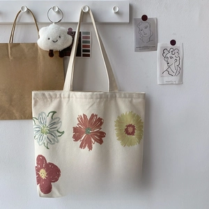 Detail of floral oil painting print on minimalist canvas tote bag with hanging straps