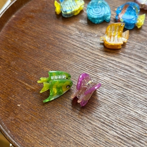 Macro shot of colorful acrylic fish hair clips with sparkling rhinestones and metal springs
