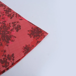 Détail du tissu bikini imprimé fleuri rouge avec des motifs à carreaux rouges et blancs