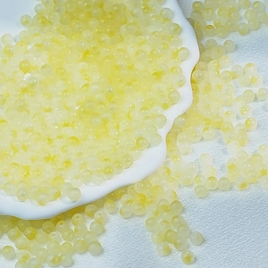 Macro detail of yellow translucent frosted 6mm glass beads for DIY jewelry making