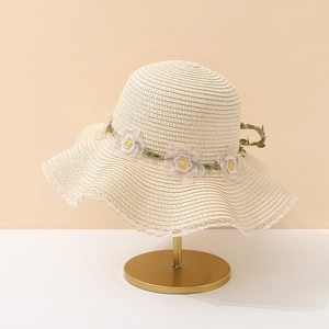 Détails de la texture du chapeau de paille crème avec feuilles vertes et dentelle blanche