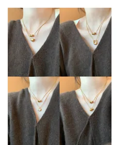 Close-up of double-layer gold titanium necklaces with heart and horseshoe charms