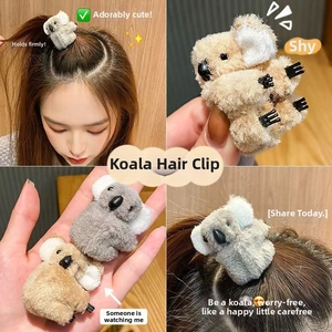 Detail view of plush koala hair clips in grey and brown showing soft texture and grip