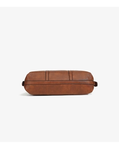 Detail of the brown tote bag base with black reinforced stitching and textured faux leather