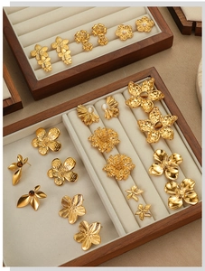 Detailed flat lay of 18K gold plated stainless steel flower earrings on velvet jewelry tray