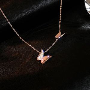 Dettaglio della collana a doppio farfalla in oro rosa con pavé di zirconi su pelle