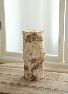 Close-up of a rustic wooden candle holder with real birch bark and a glass insert